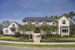 Center two-story brick house with two-story lap siding mass on right side and one-story lap siding mass on left. Full front porch across brick part of house with center masonry stair.