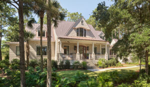 Front façade of English Arts and Crafts style home with a coastal influence showcasing flared copper roofs and shingle siding.