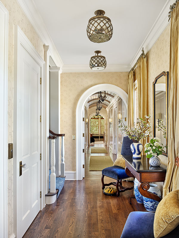 Elegant stair hall leading towards barrel vaulted master hallway beyond.